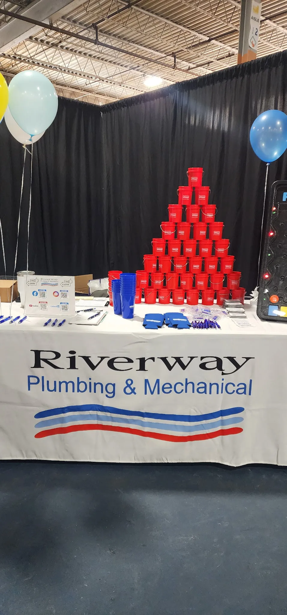 Riverway Plumbing and Mechanical community outreach booth with brand banners and team engagement materials